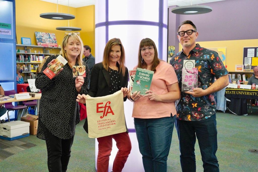 Three women and a man holding up an EFA tote and books